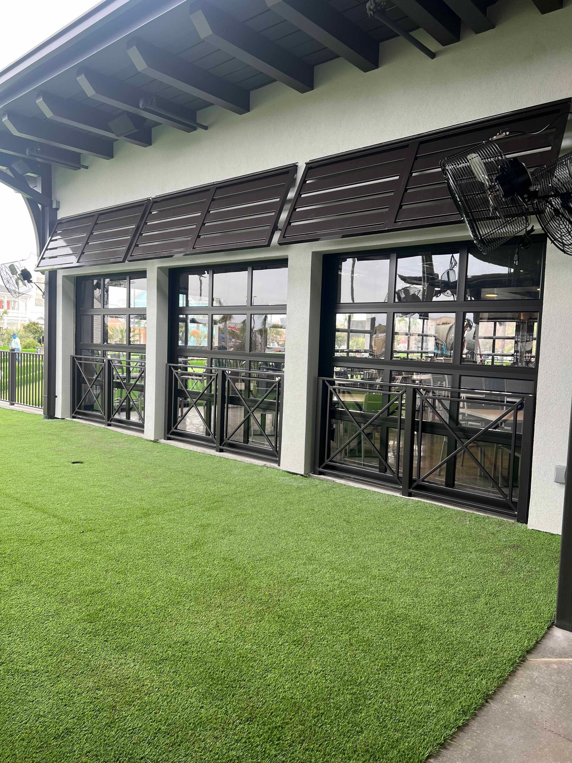 A building with a lot of windows and a lot of grass in front of it.