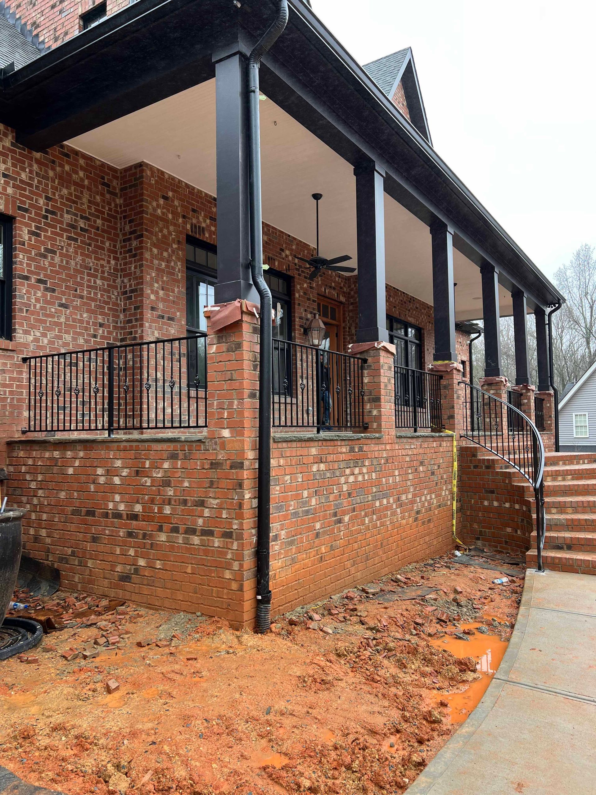 A large brick house with a porch and stairs