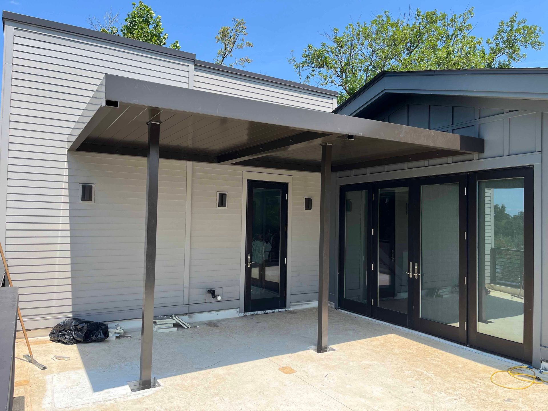 A house with a covered patio and sliding glass doors.