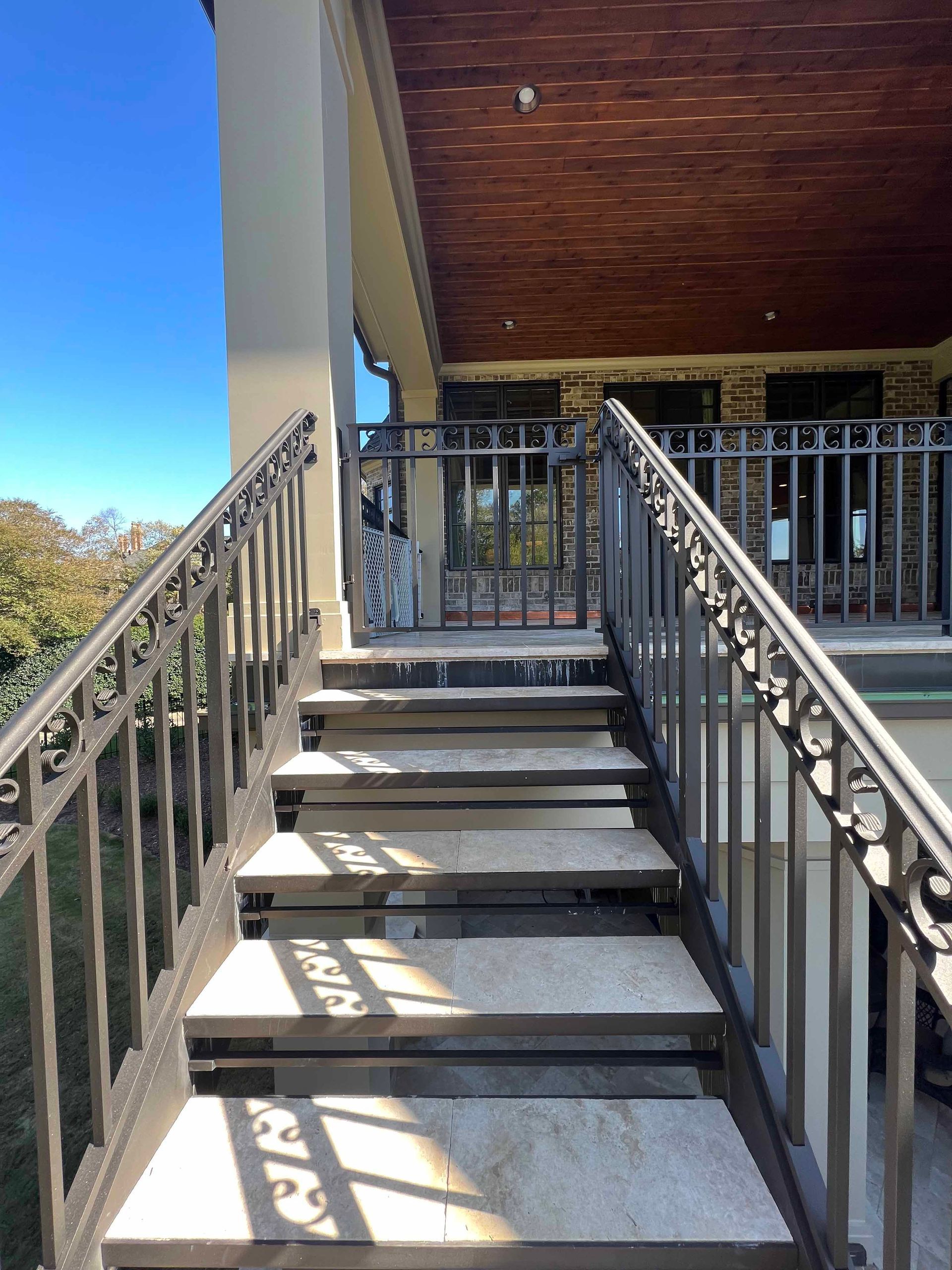 A set of stairs leading up to a balcony with a metal railing