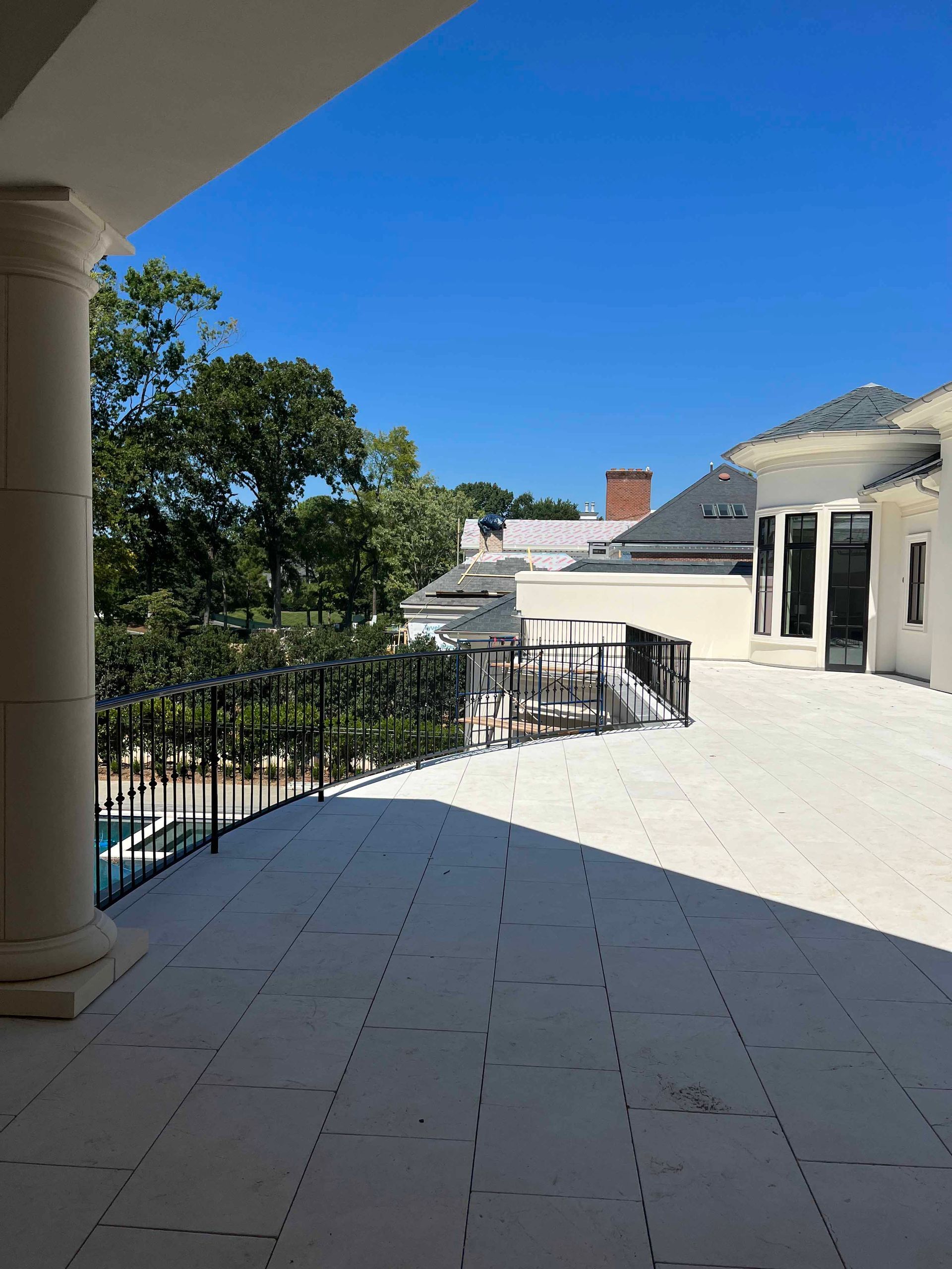A balcony with a view of a house and trees