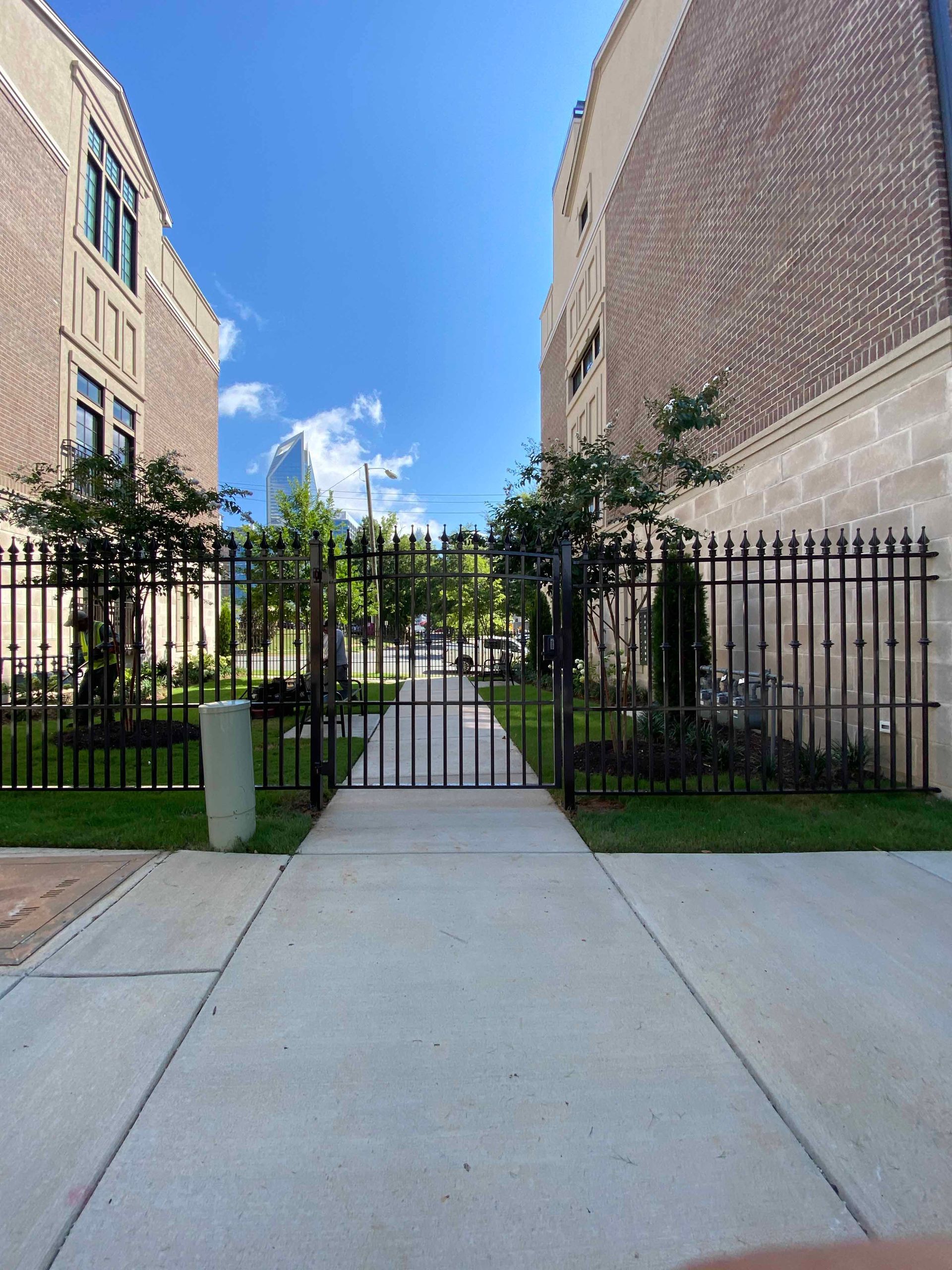 A walkway between two buildings with a gate in the middle