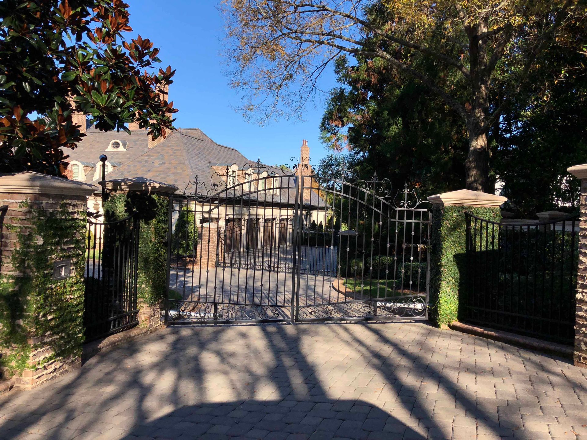A gated driveway leading to a large house