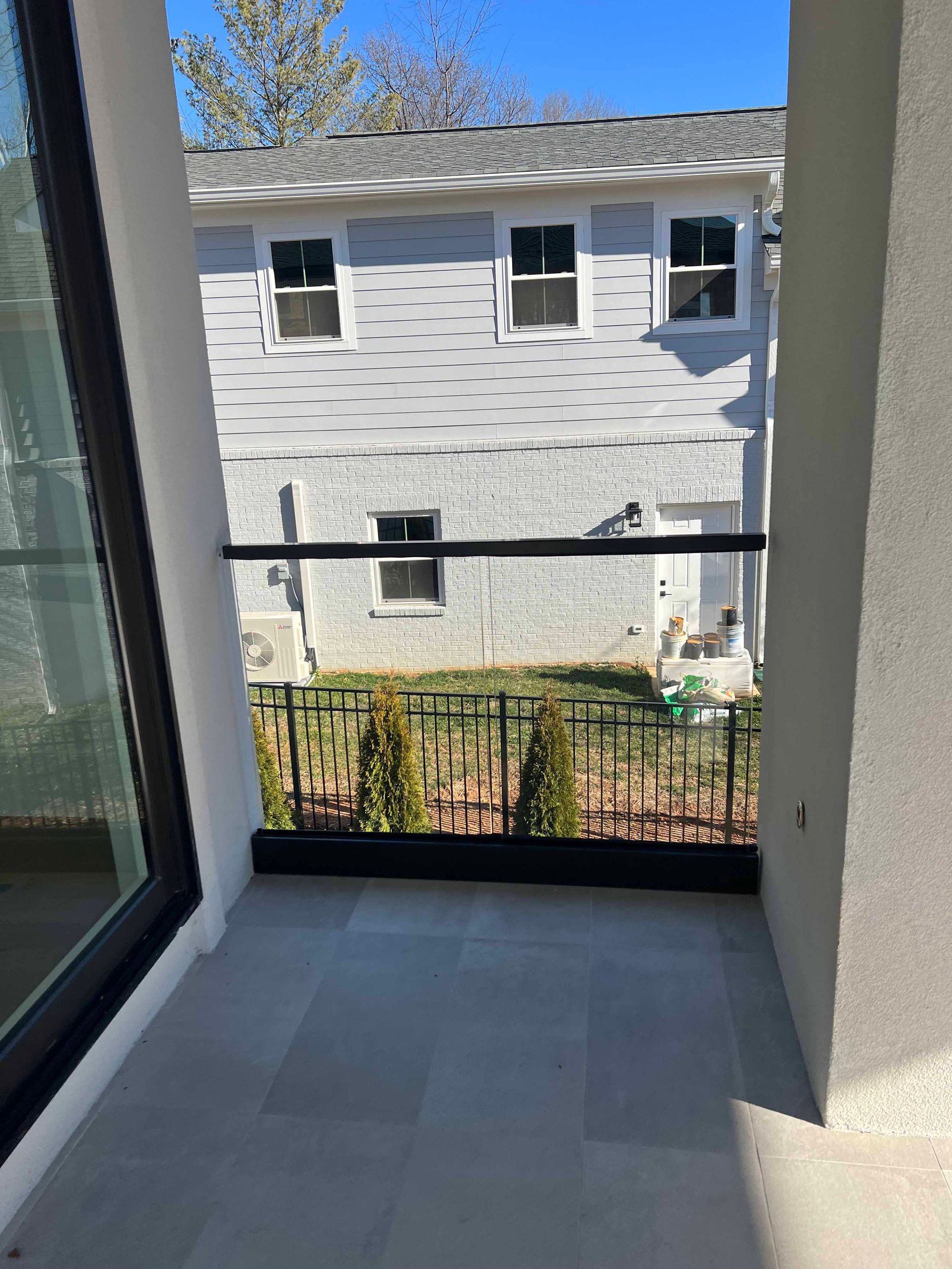 A balcony with a railing and a view of a house.