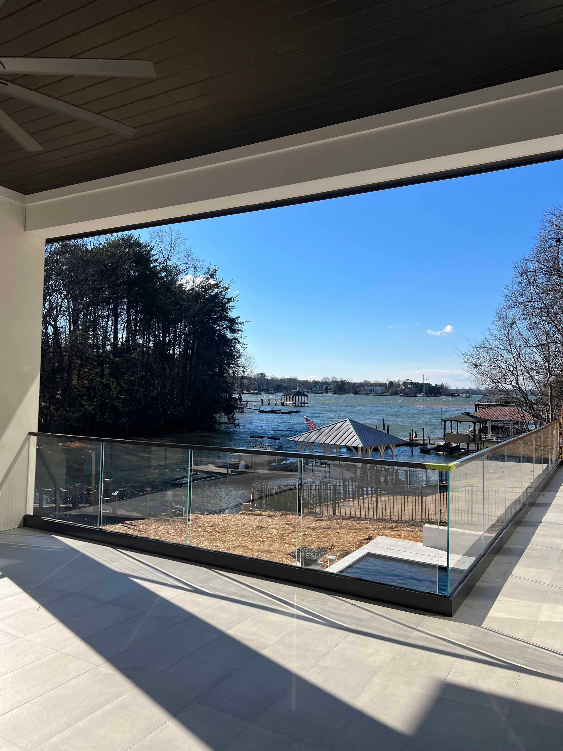 A balcony with a view of a body of water and trees.