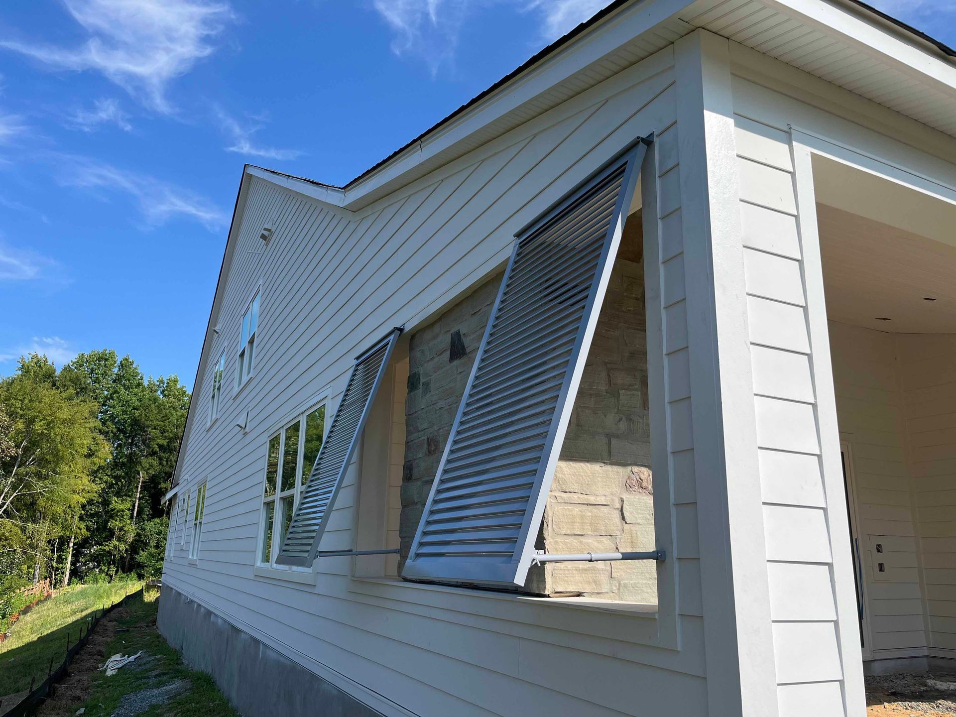A white house with shutters on the side of it