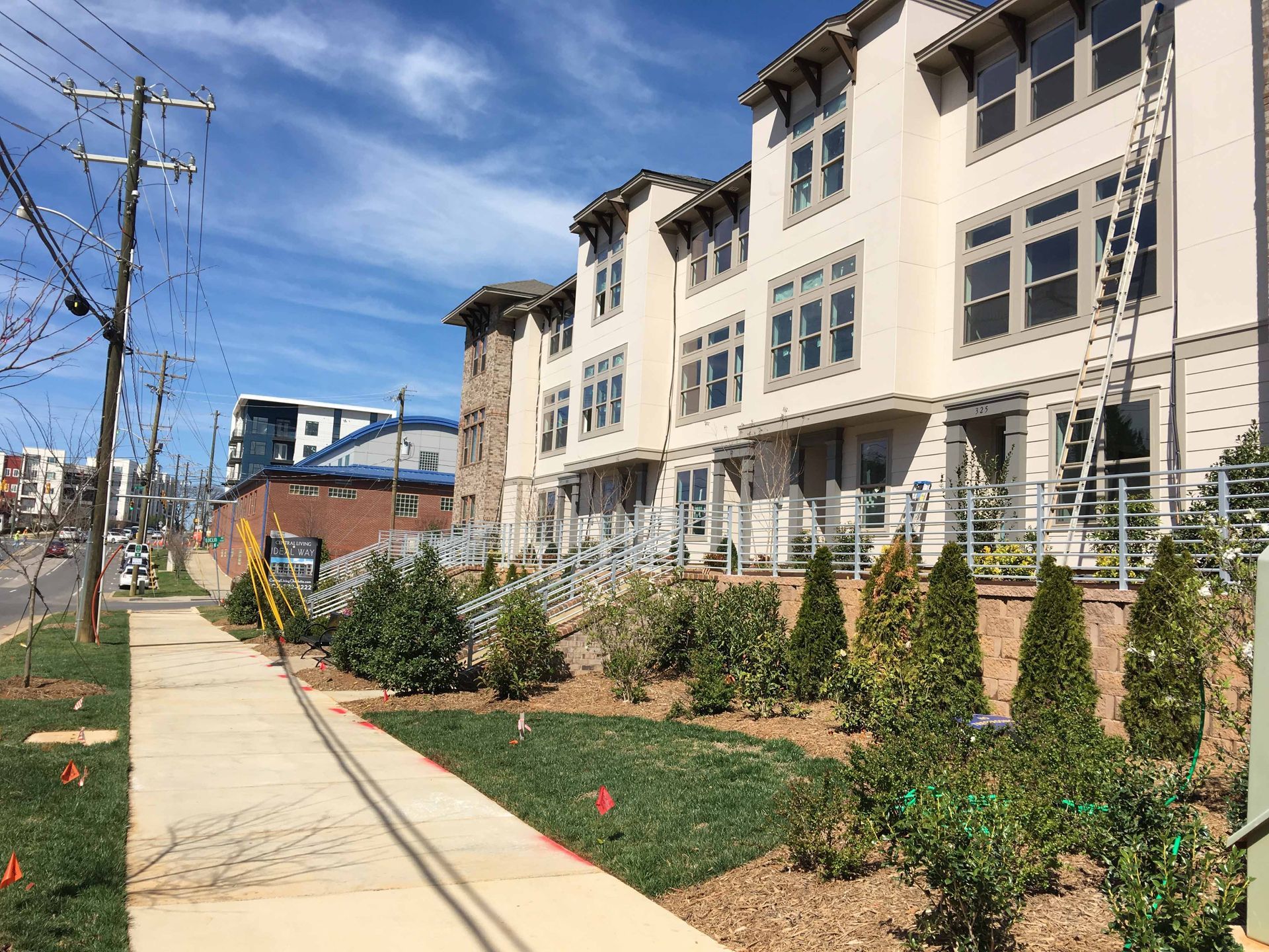 A large building with a lot of windows is sitting next to a sidewalk.