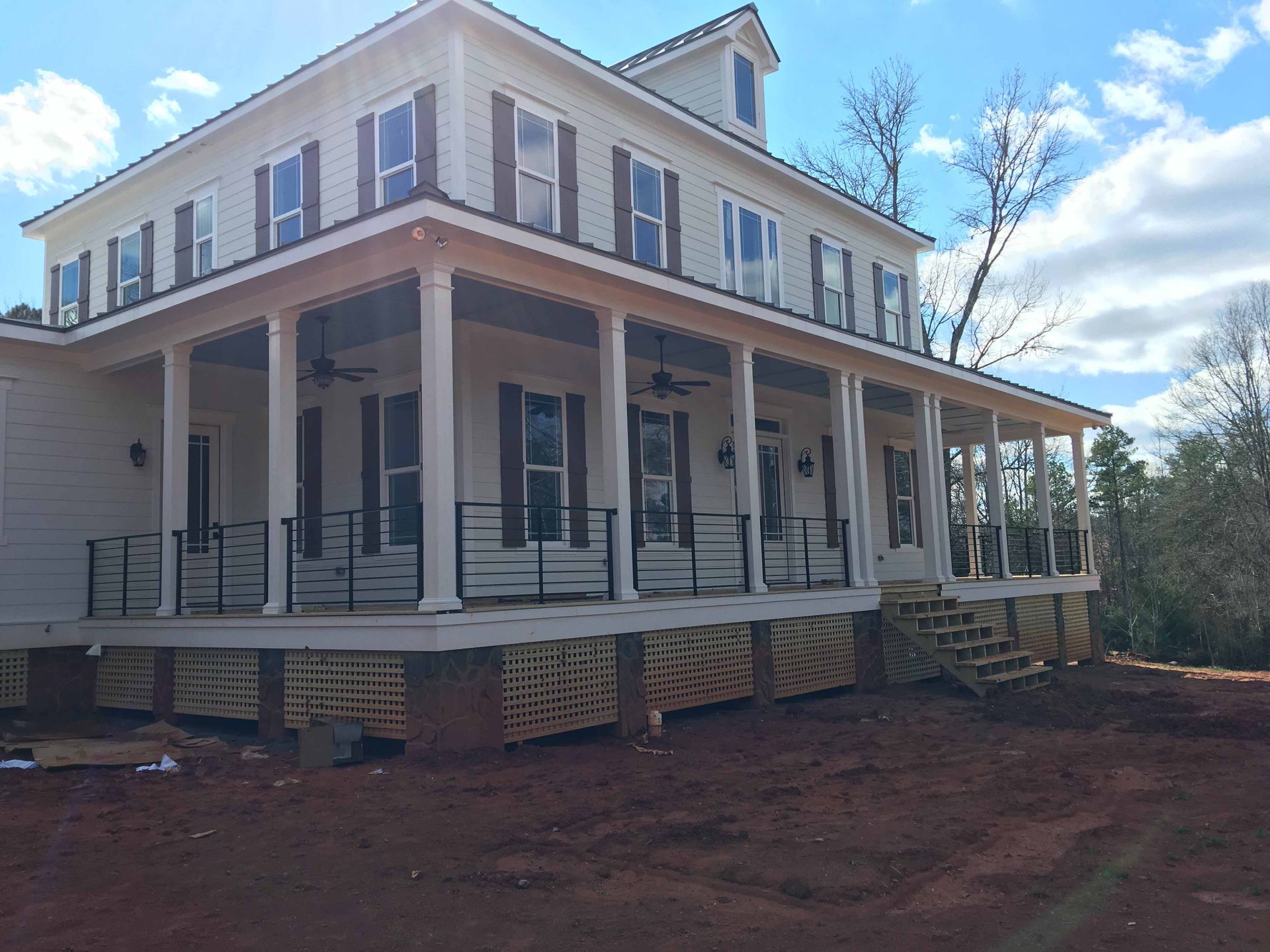 A large white house with a large porch and stairs