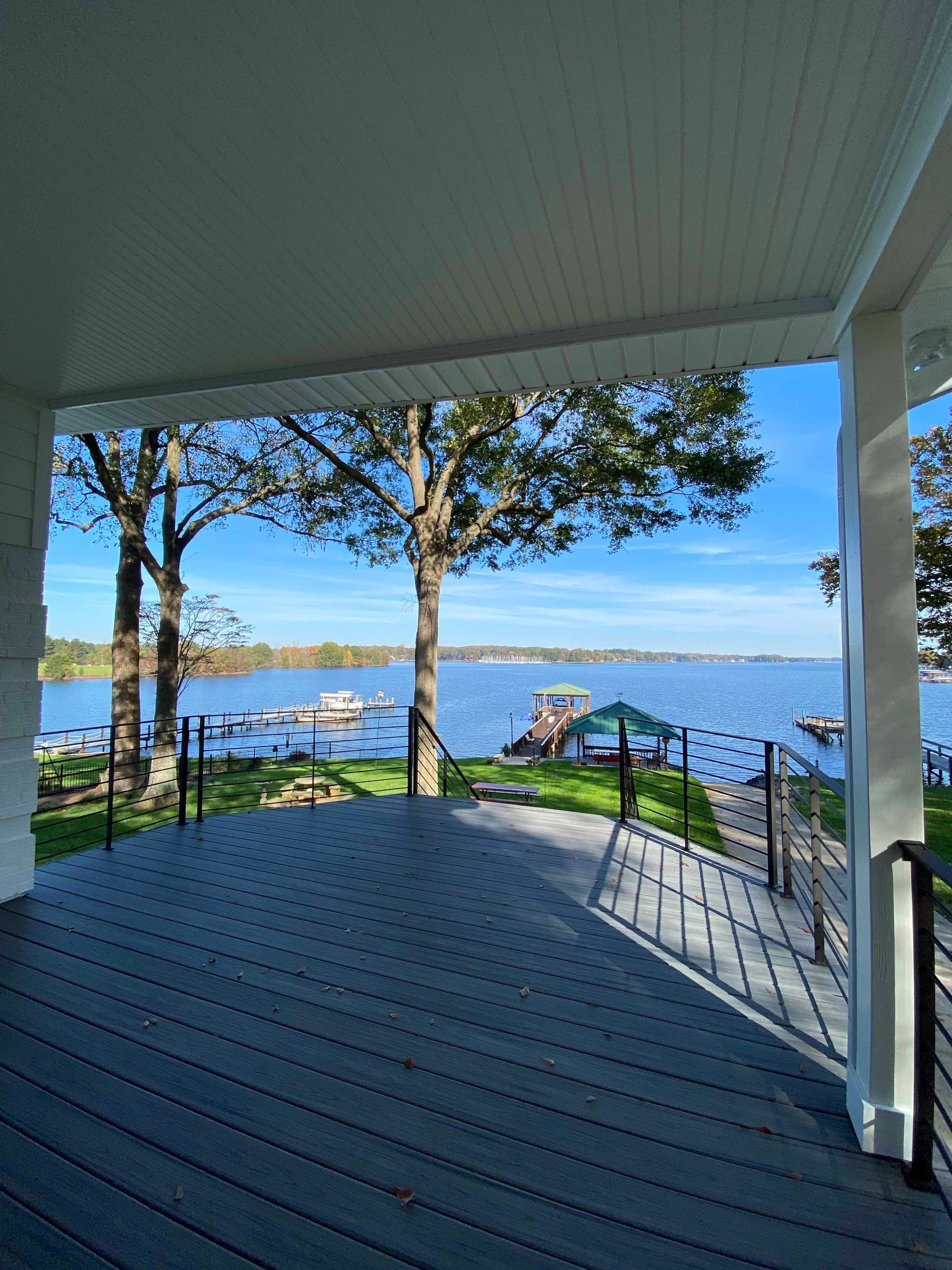 A large deck with a view of a lake and trees.