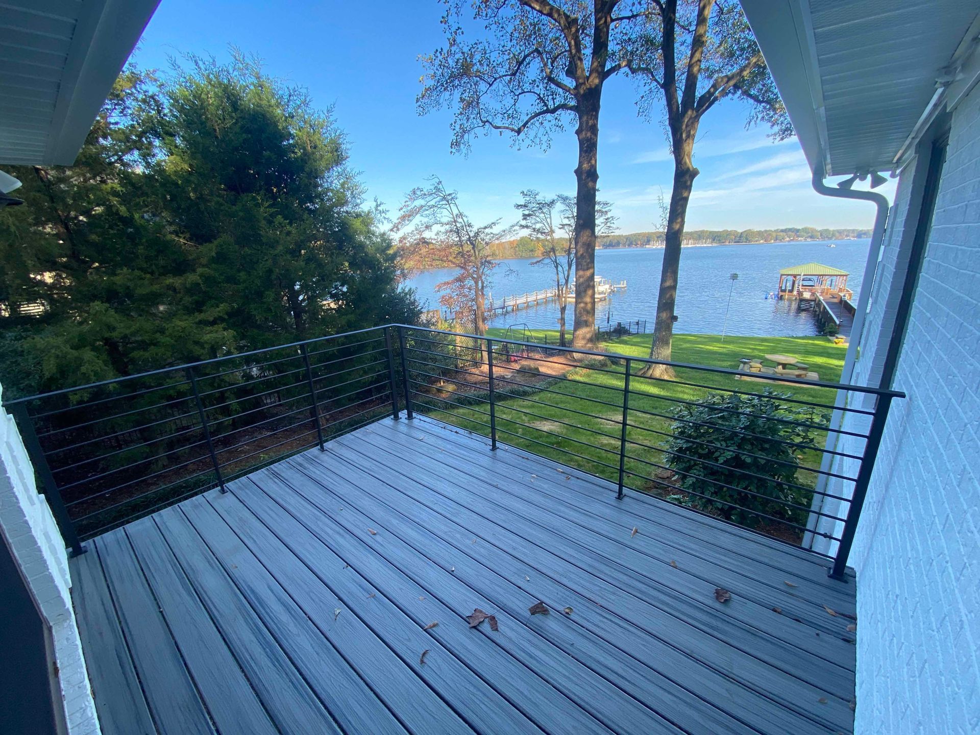 A deck with a view of a lake and trees.
