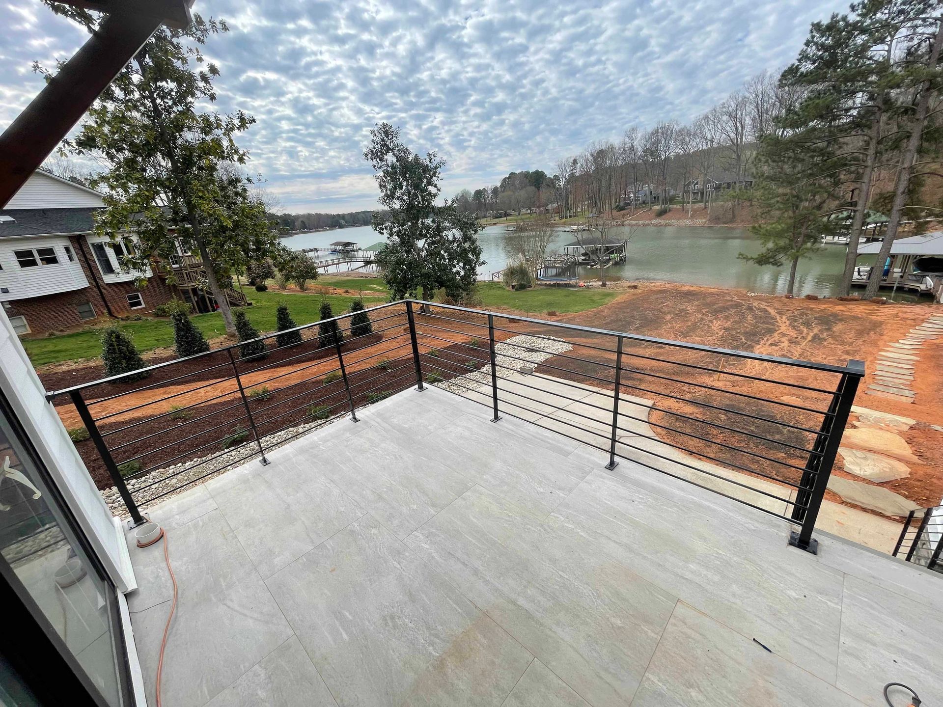 A balcony with a view of a lake and trees.