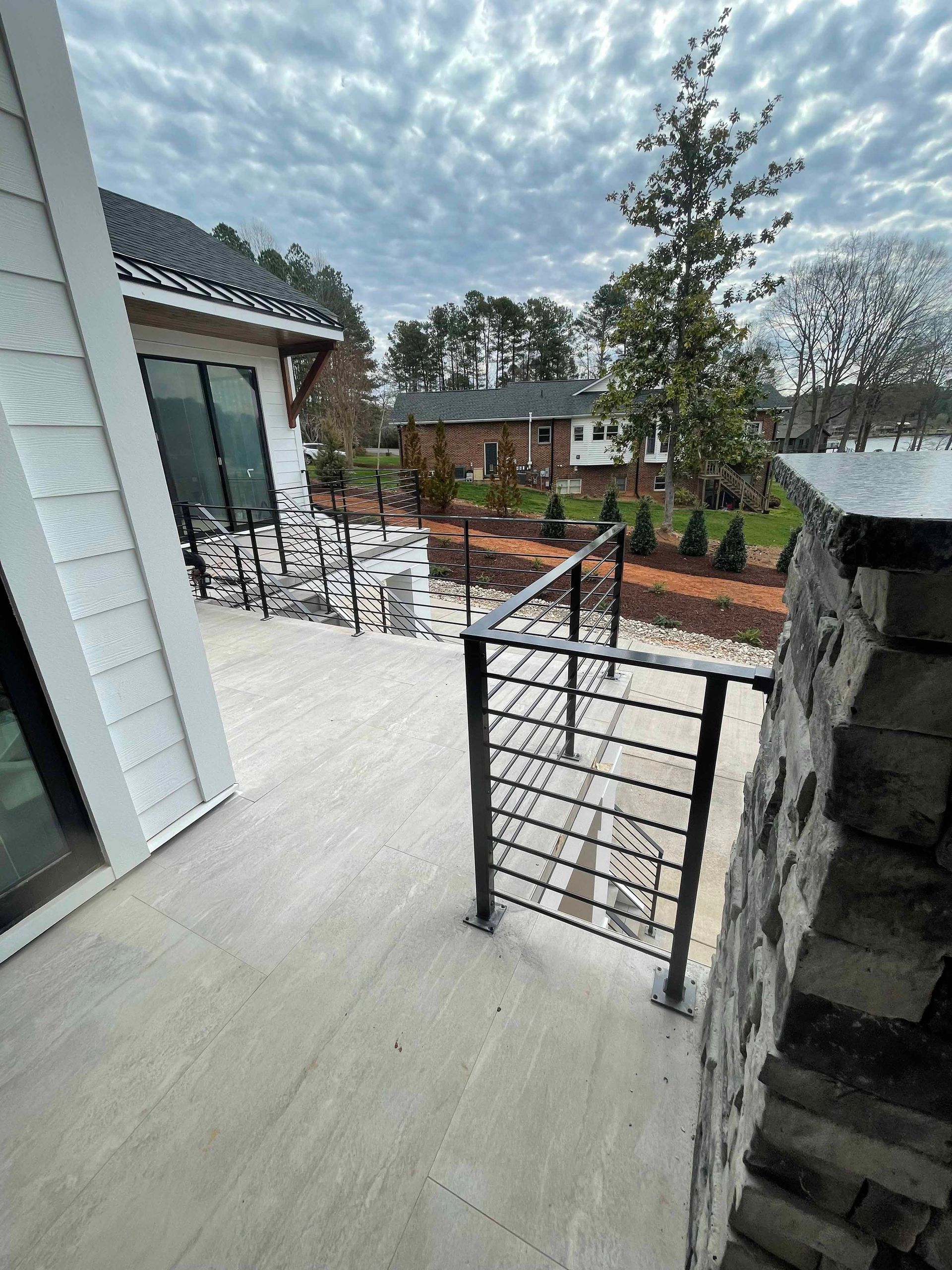 A balcony with a railing and stairs leading up to a house.