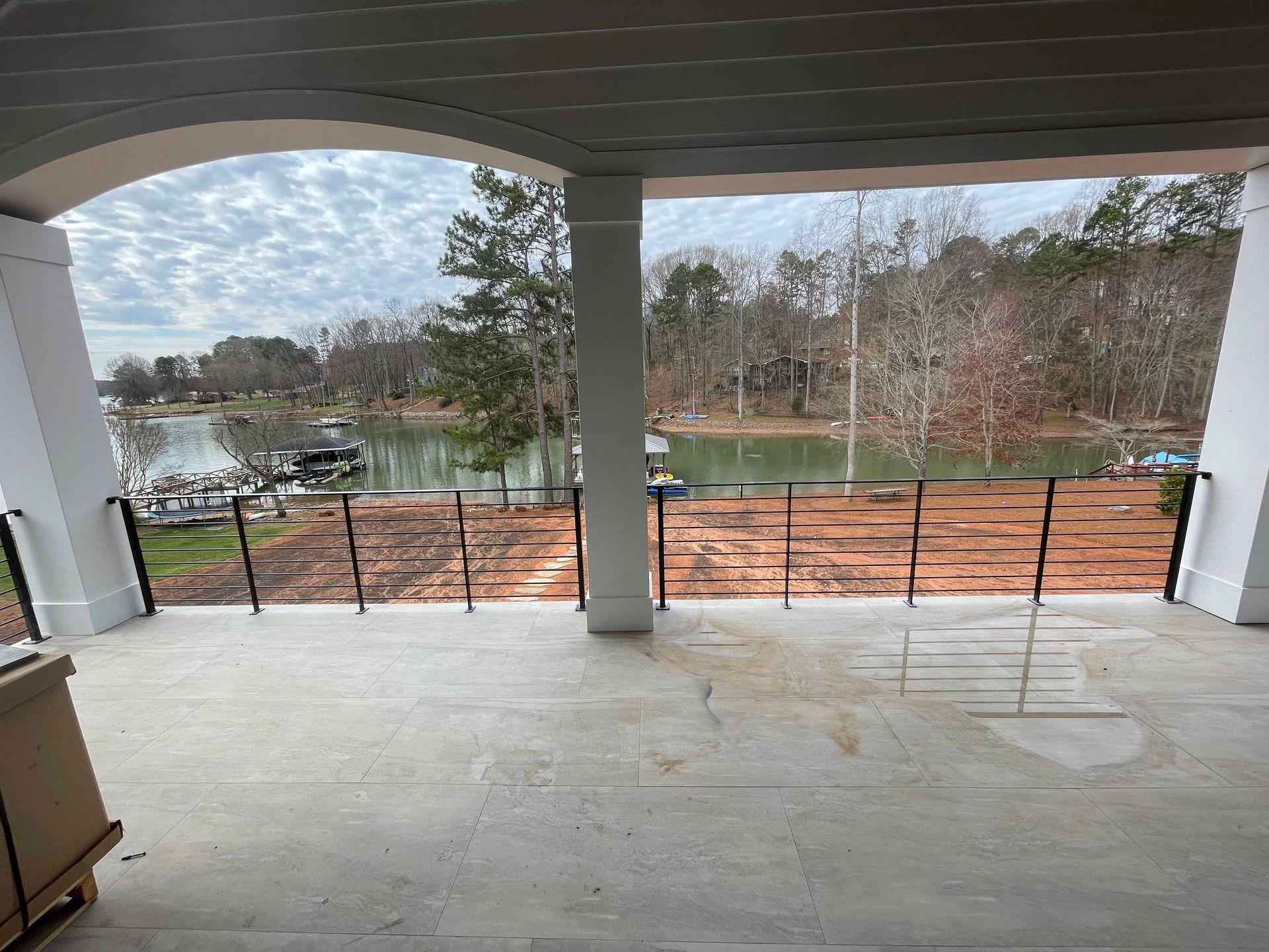 A balcony with a view of a lake and trees.