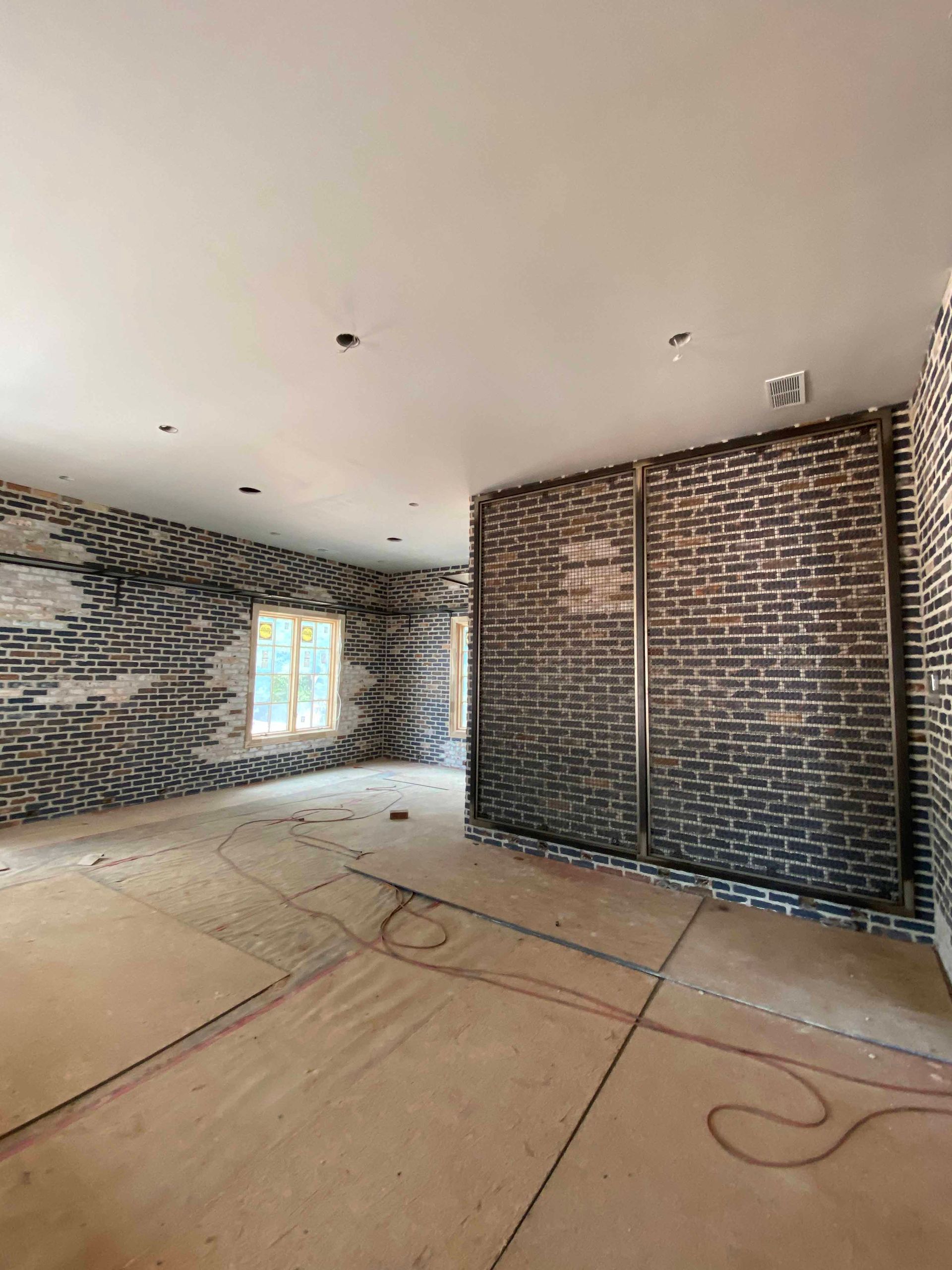 An empty room with brick walls and a wooden floor.