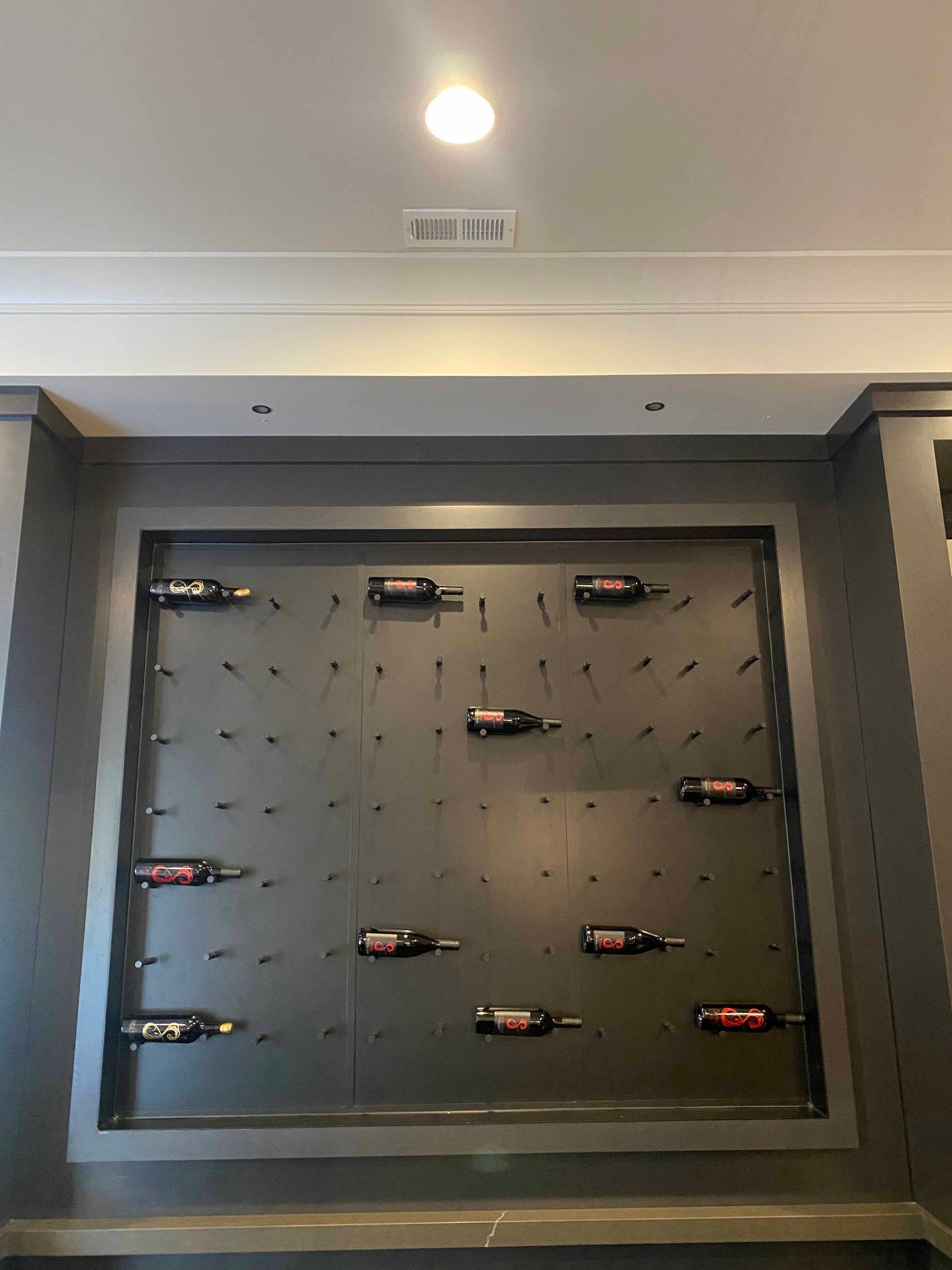 A wall with many bottles of wine on it