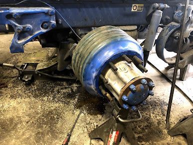 A blue wheel is sitting on top of a jack.