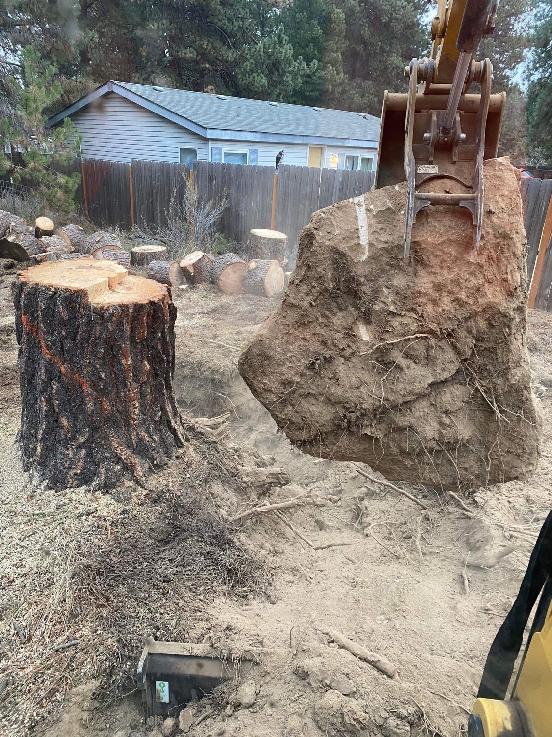A large rock is being lifted out of the ground by a bulldozer.