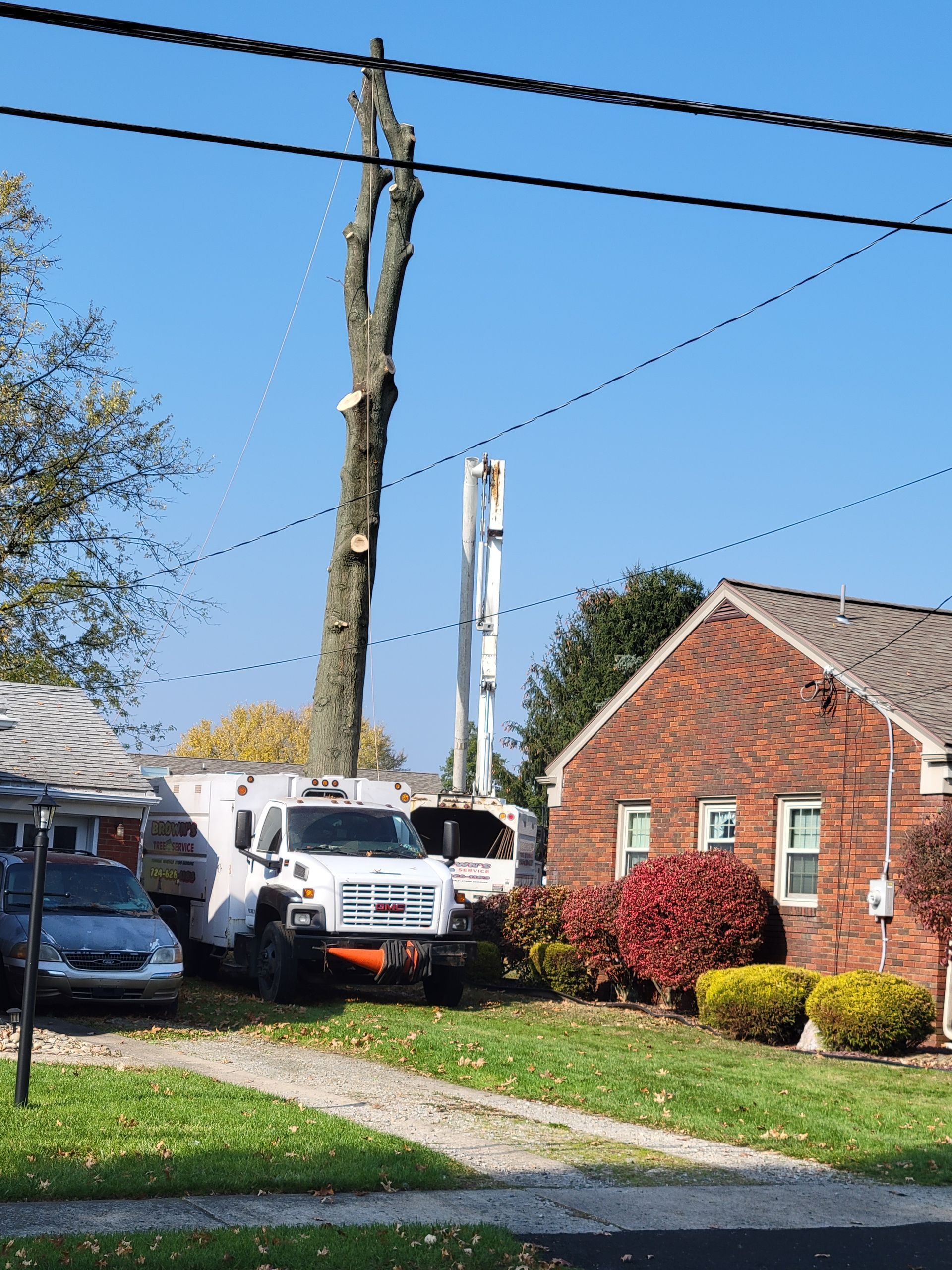 A white truck is parked in front of a brick house
