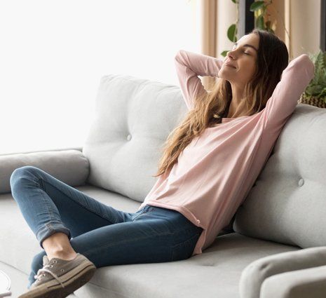 Woman sitting in a couch inside her clean house