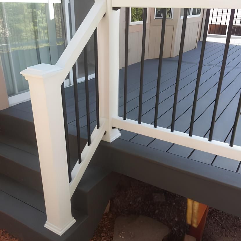 A deck with a white railing and black bars