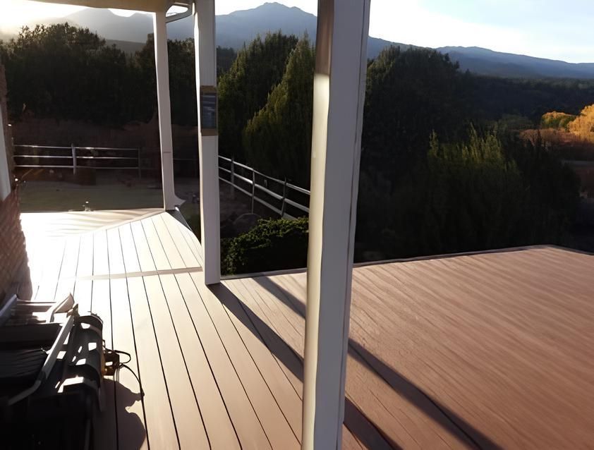 A wooden deck with a view of mountains and trees