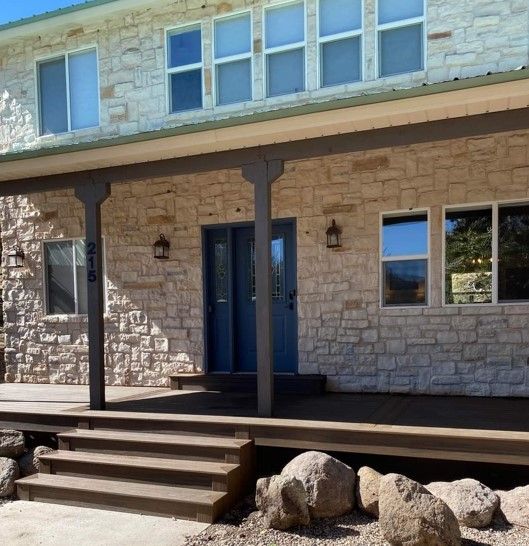 A large brick house with a porch and stairs