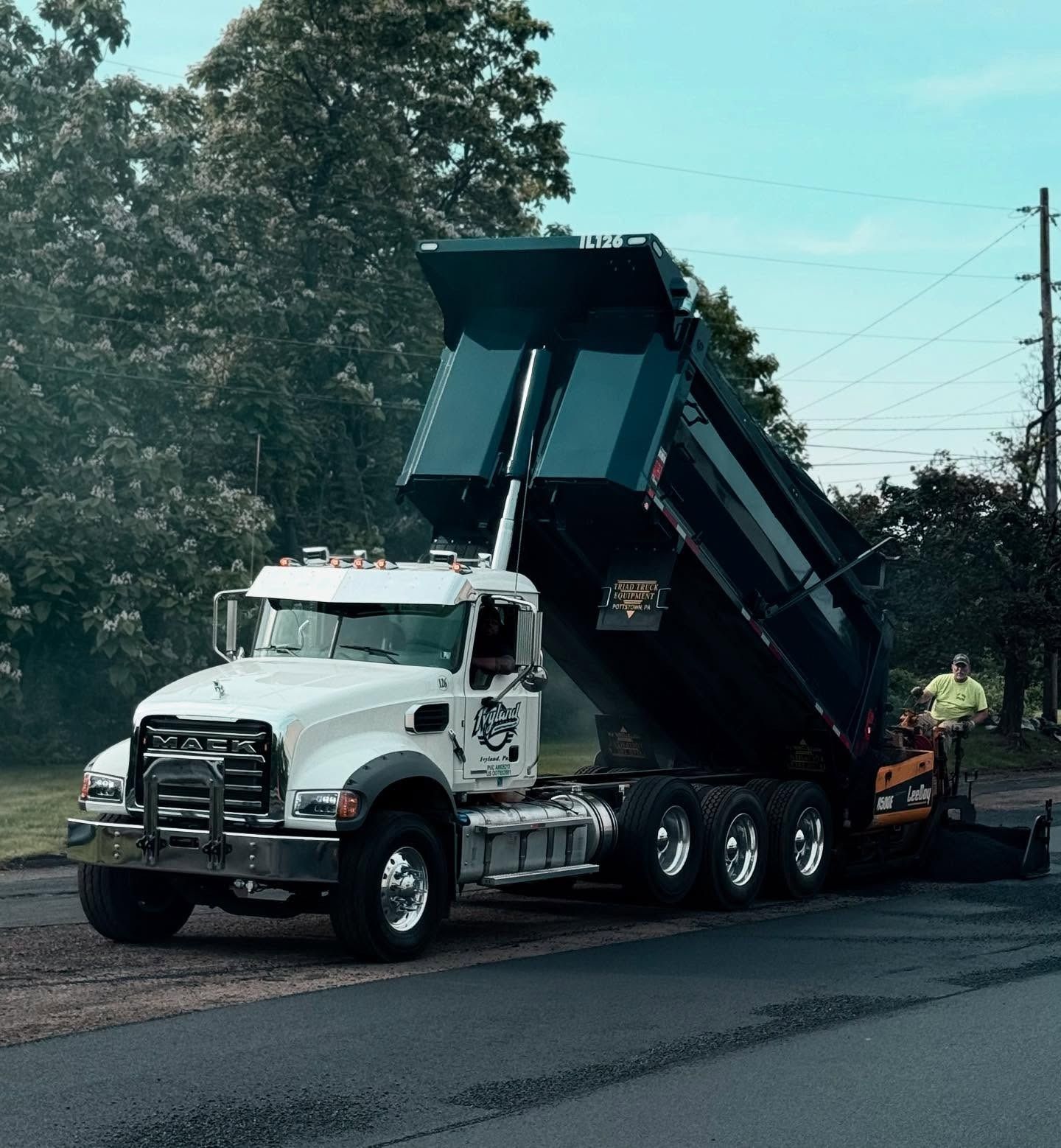 A dump truck is parked on the side of the road