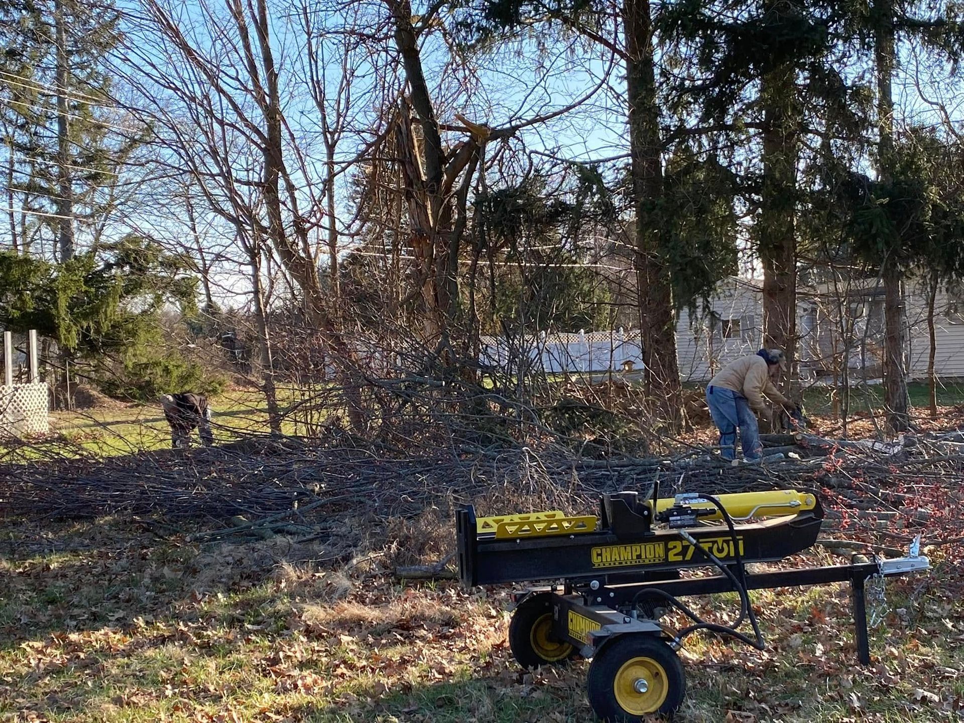 A man is using a log splitter in the woods.