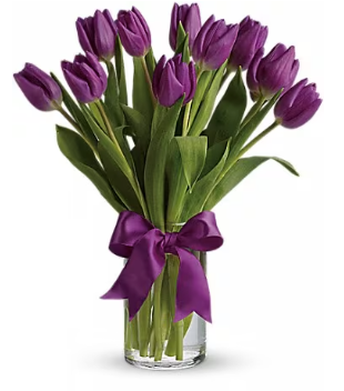 a vase filled with purple tulips with a purple bow