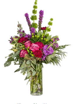 a vase filled with purple and pink flowers on a white background .