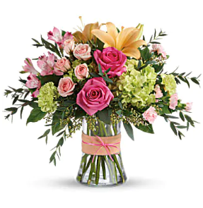 a vase filled with pink roses , lilies , and greenery .