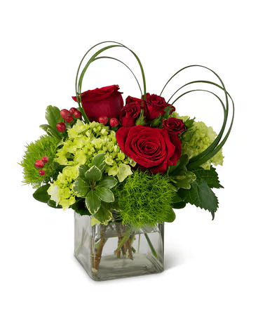 A vase filled with red roses and green flowers on a white background.