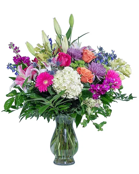A vase filled with a variety of flowers on a white background.