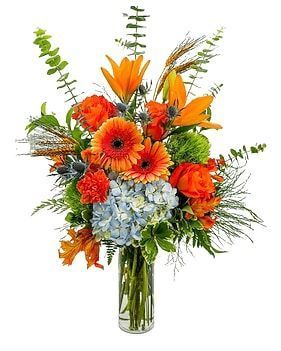 Orange and blue flower arrangement in a glass vase.
