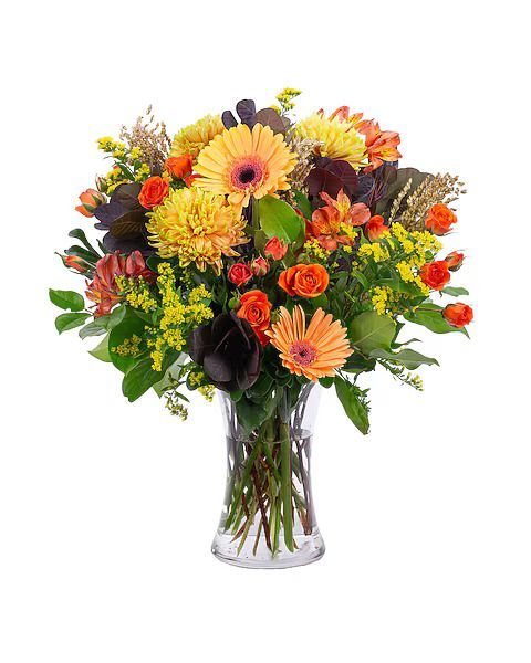 Bouquet of orange and yellow flowers in a clear glass vase.