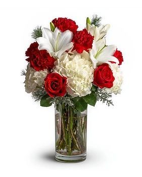 Bouquet of red and white flowers, including lilies, carnations, and roses in a glass vase.
