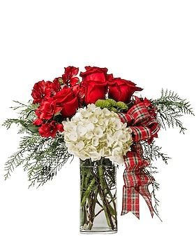 Flower arrangement: red roses, white hydrangea, red carnations, greenery, plaid ribbon in a glass vase.