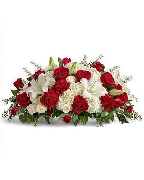 Arrangement of red roses, lilies, and carnations with greenery, a floral casket spray.