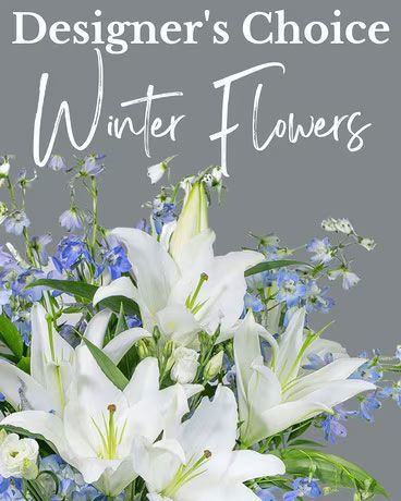 Designer's Choice winter flower arrangement: white lilies, blue accents, against gray background.