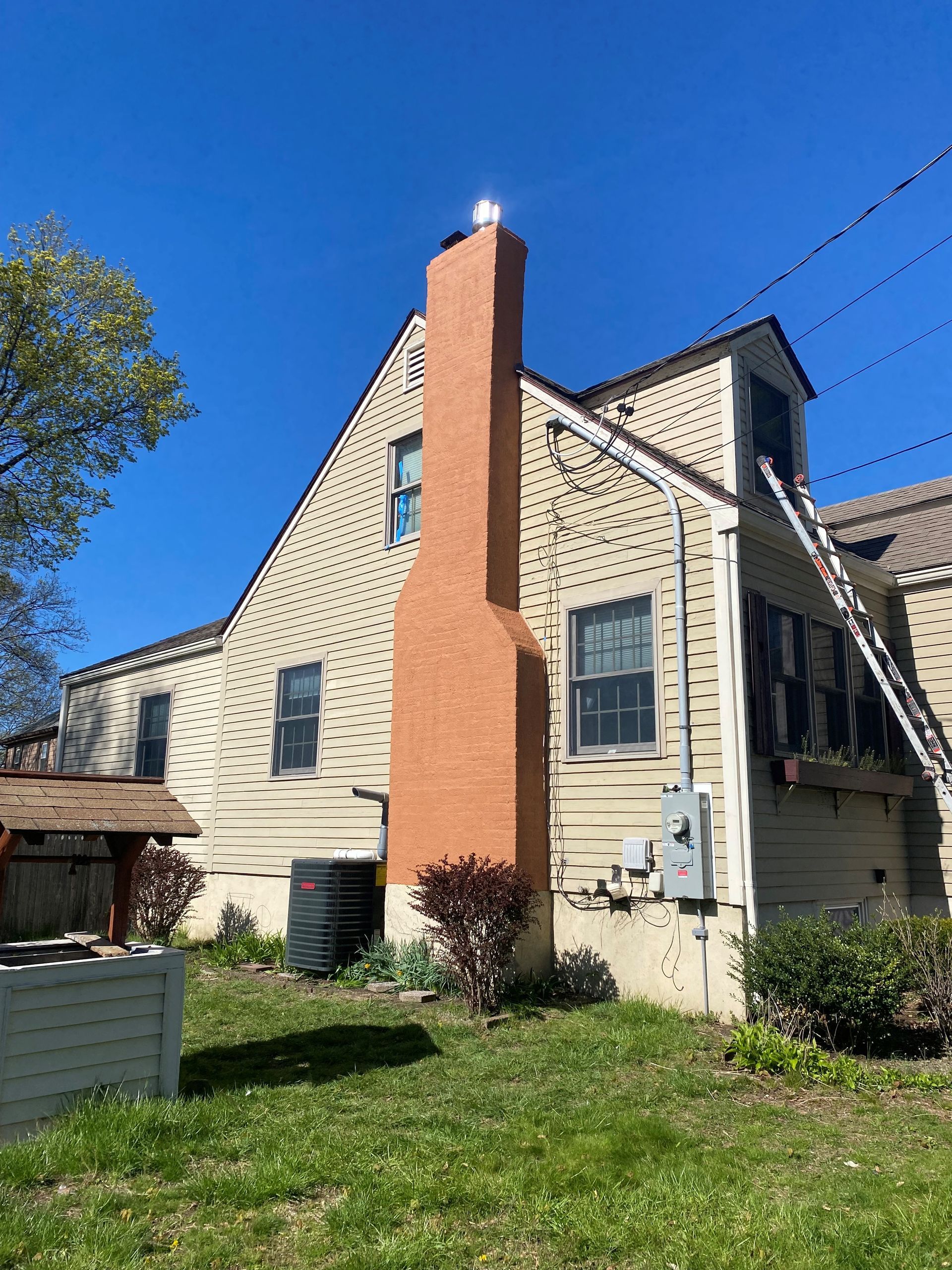 A large house with a large chimney on the side of it.
