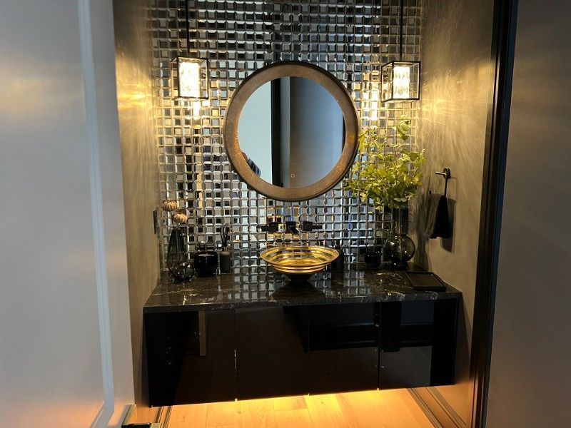 A bathroom with a round mirror and a sink.