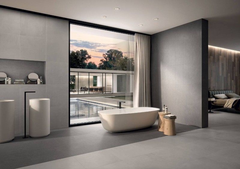 A bathroom with a bathtub , sink , and large window.