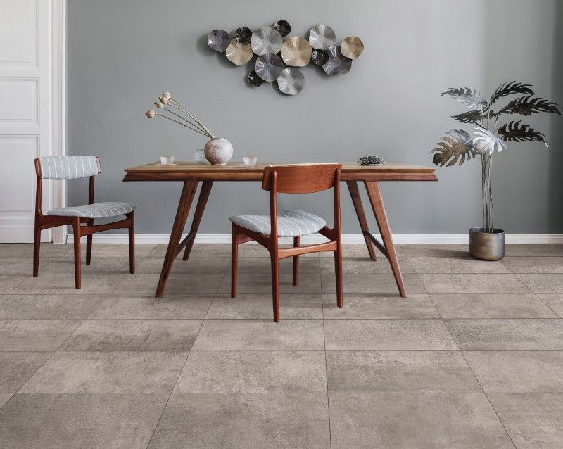 A dining room with a table and chairs and a plant.