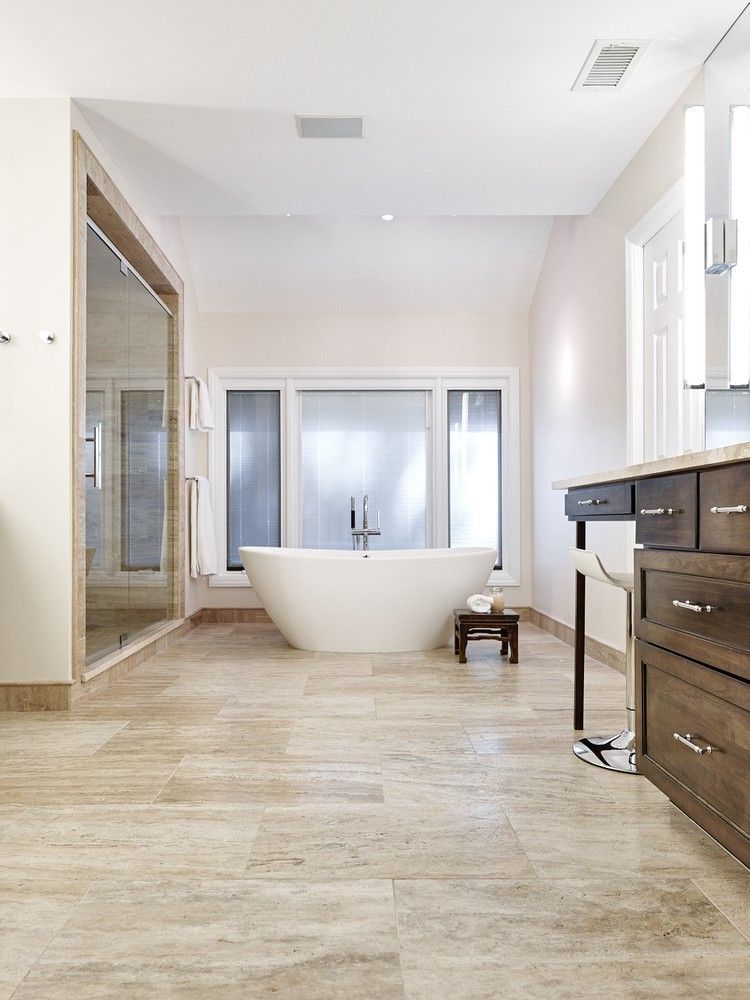 A bathroom with a tub , sink , and mirror.