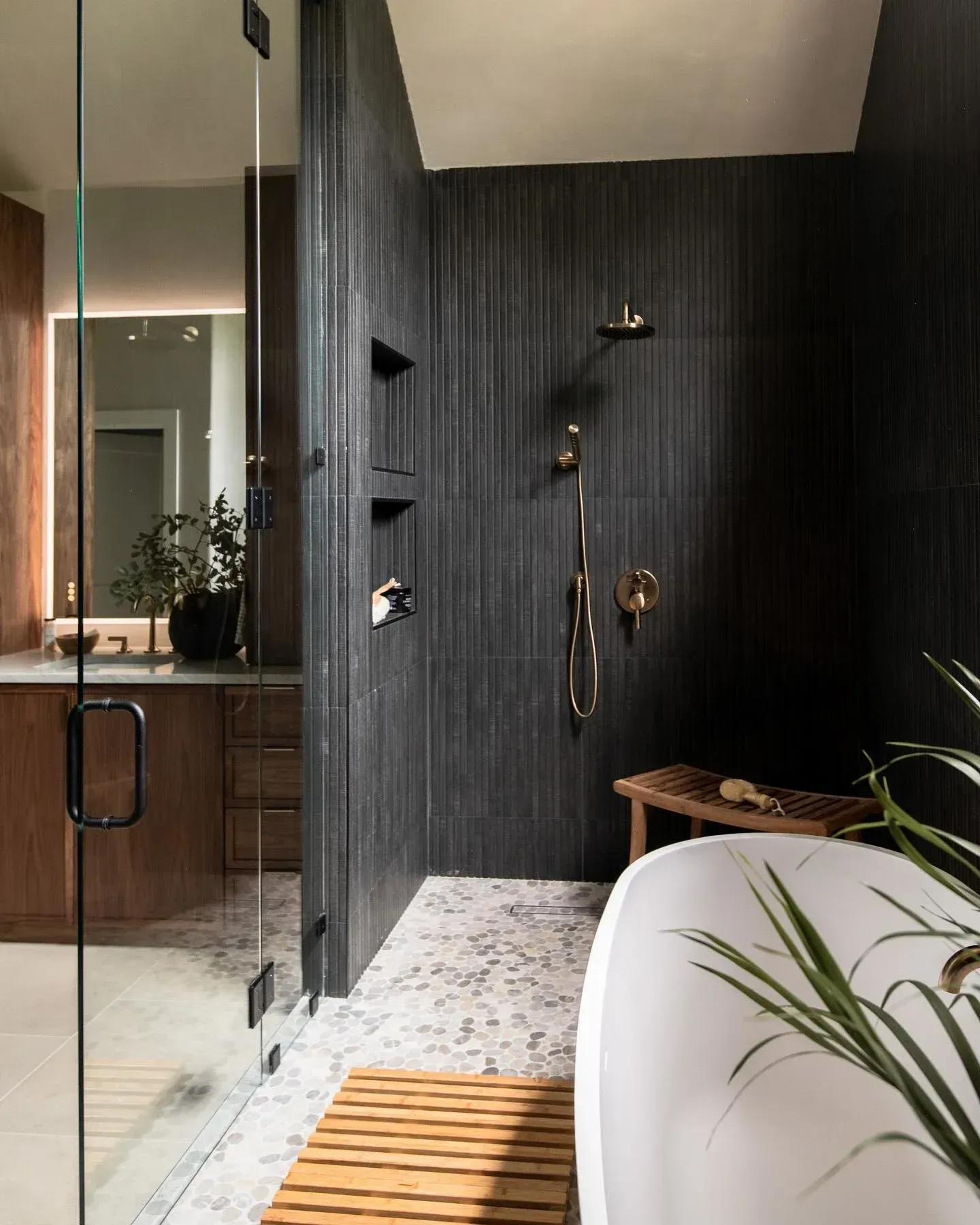 A bathroom with a bathtub , shower , sink and mirror.