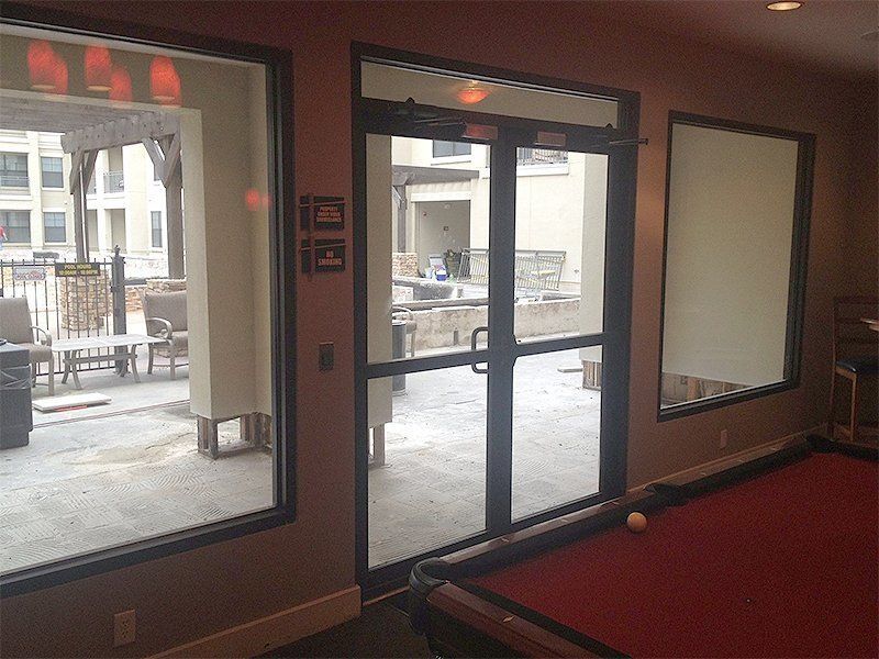 Lobby entrance with glass doors, windows, and a red carpeted floor overlooking a courtyard.