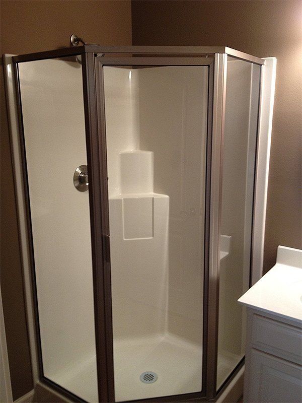 Corner shower stall with clear glass doors in a bathroom
