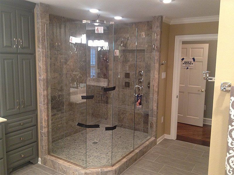 Glass-enclosed shower with stone tile walls in a modern bathroom
