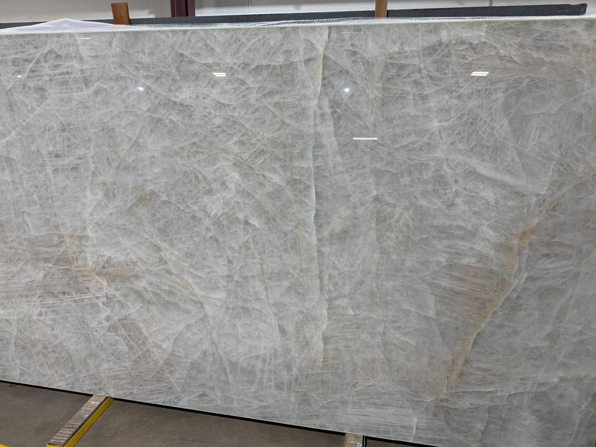 Large white marble slab standing upright in an industrial showroom or storage area.