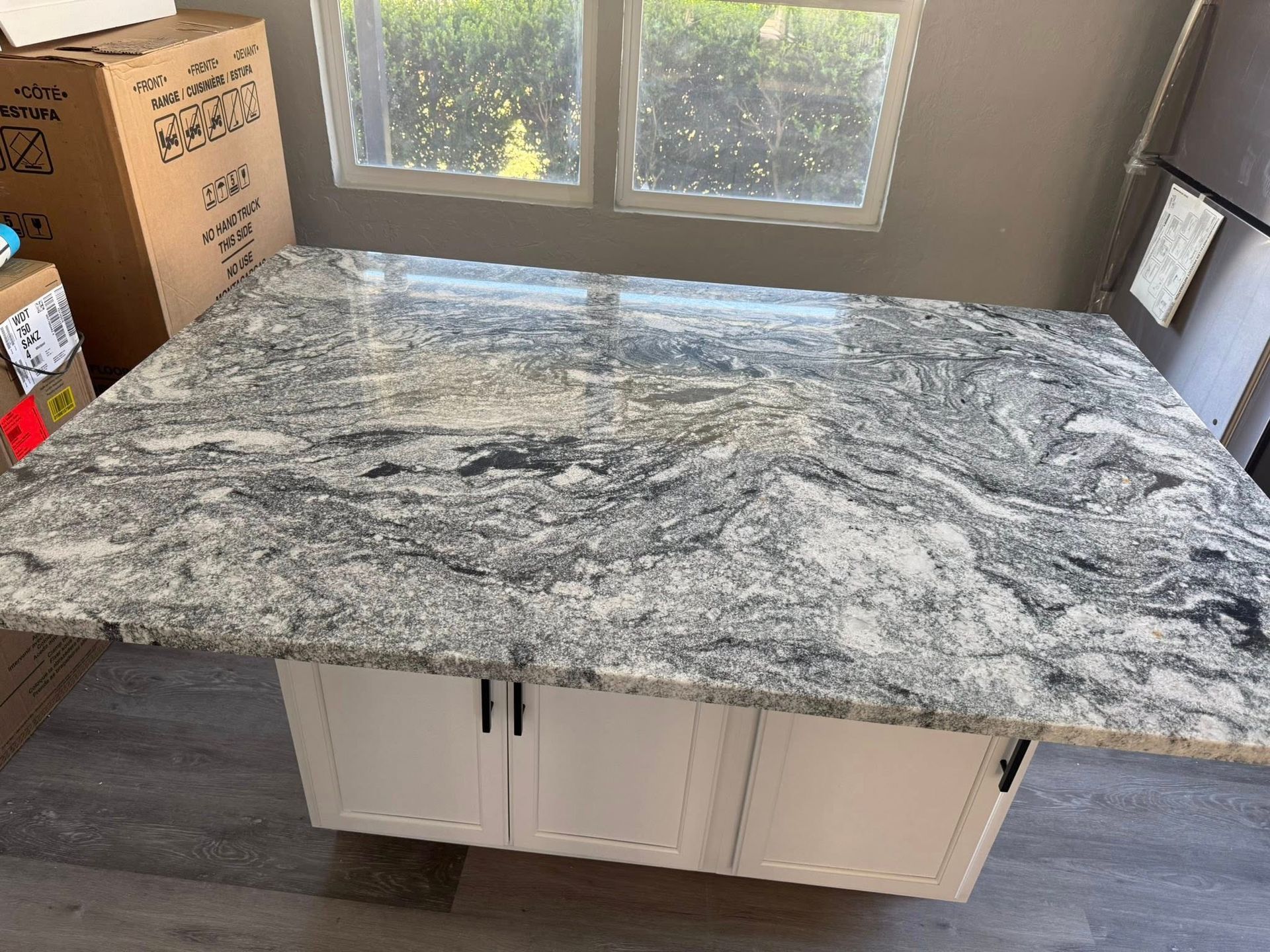 Granite-pattern countertop installed on a white cabinet base in a bright room